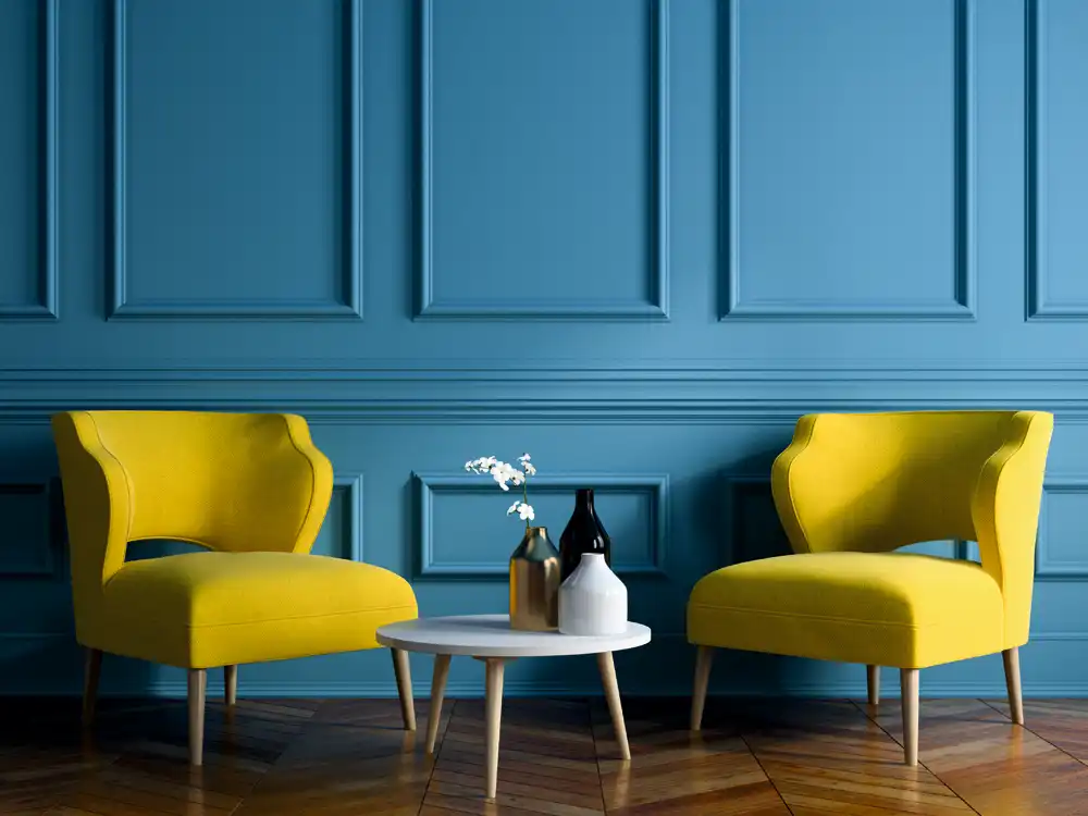 Paintable blue wainscot feature wall with bright yellow chairs